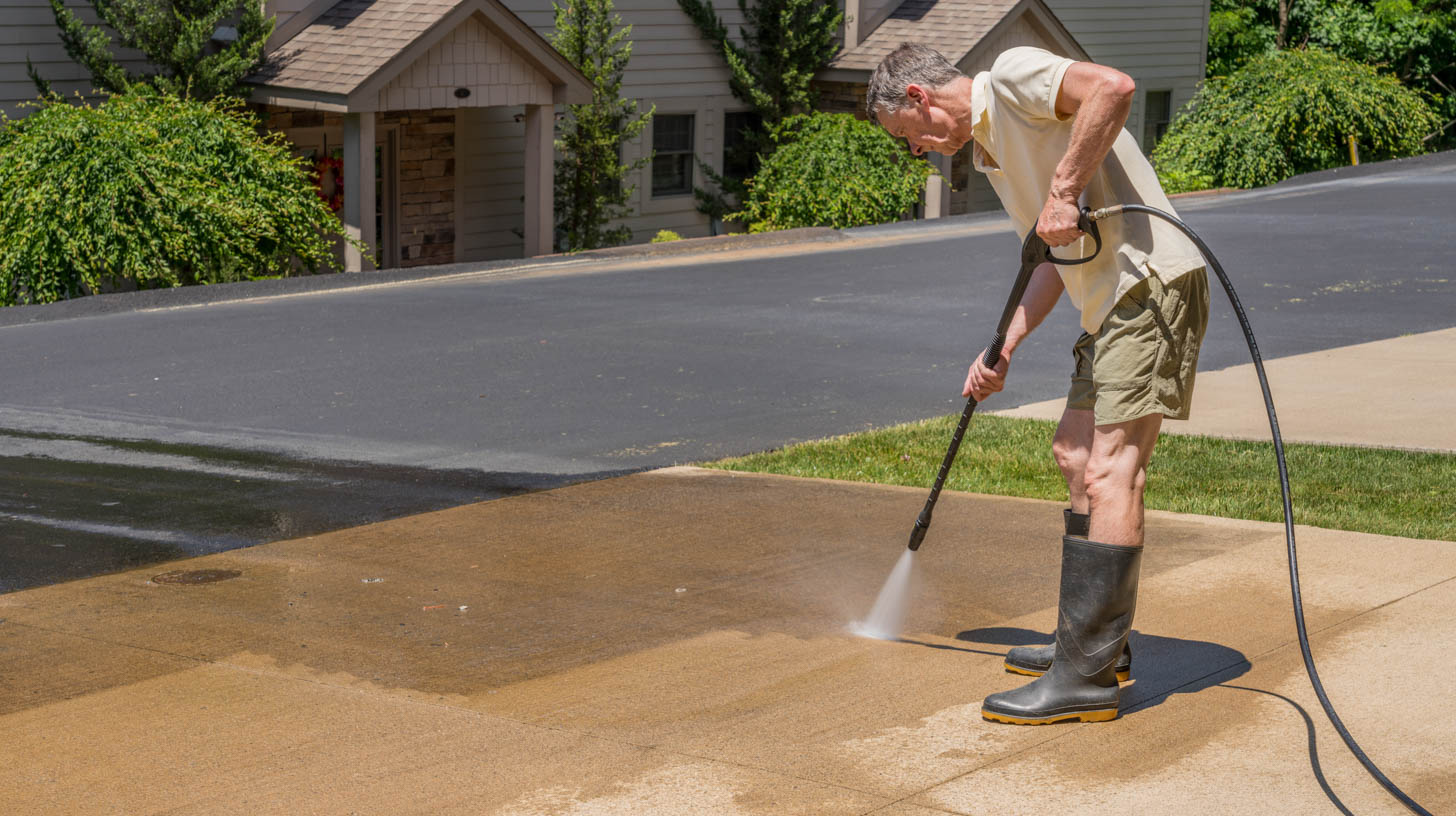 Man pressure cleaning his driveway